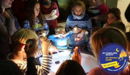 Eine Gruppe Kinder mit Taschenlampen im Museum.