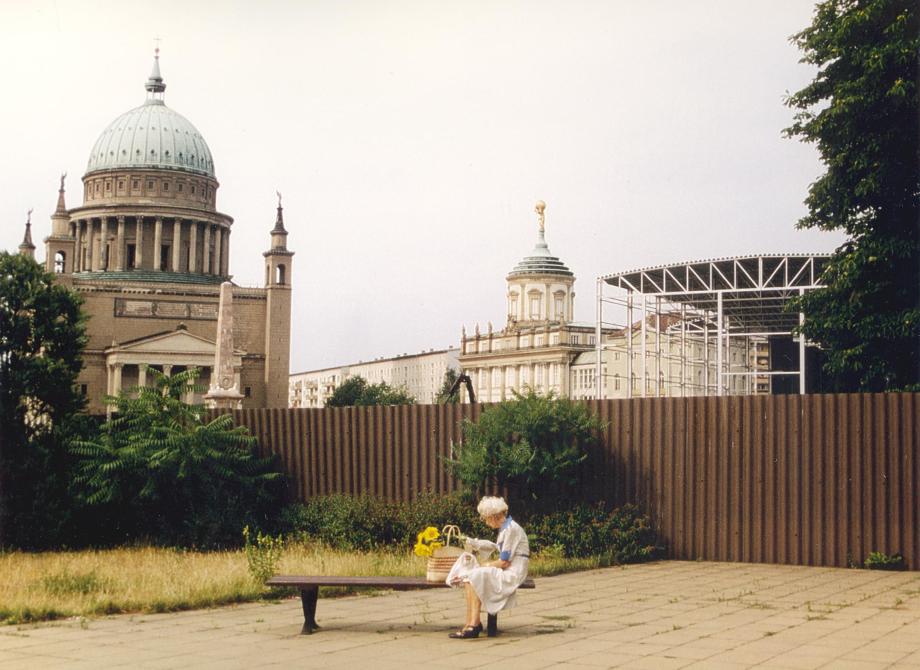 Ältere Dame sitz auf einer Bank am Alten Markt