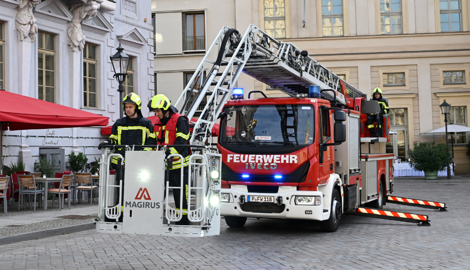 Feuerwehr vor dem Museum, zwei Feuerwehrmänner auf der Drehleiter.