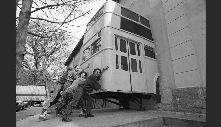 Junge Männer schieben ein Autotorso-Kunstobjekt