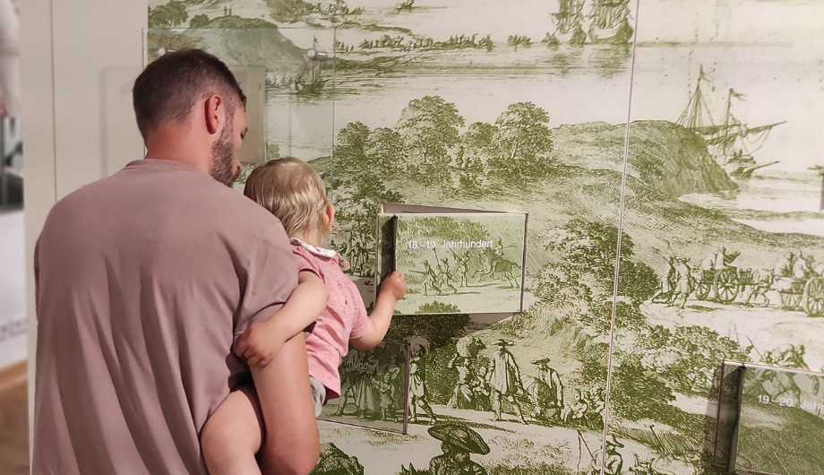 Mann mit Kind in der Stadtgeschichtlichen Ausstellung 
