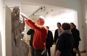 Ein blinder Mann ertastet eine Skulptur in der stadtgeschichtlichen Ausstellung
