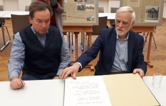 Michael Zajonz und Michael Heinroth präsentieren das Besucherbuch zur Ausstellung,