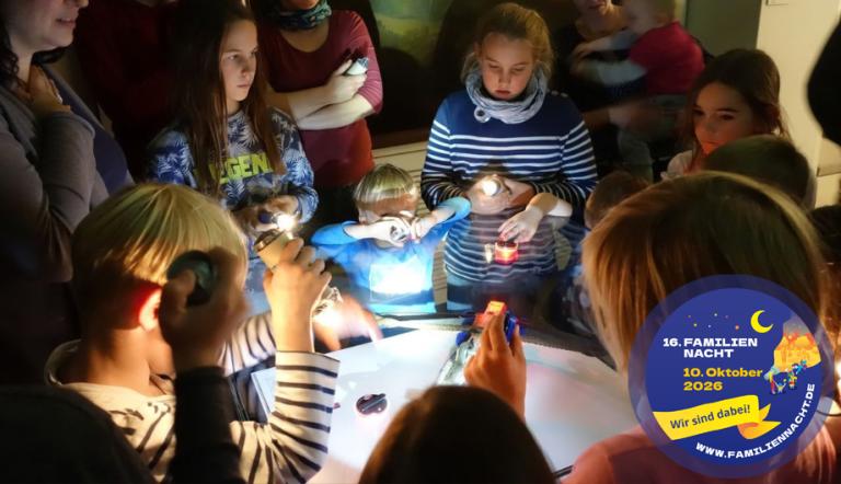 Eine Gruppe Kinder mit Taschenlampen im Museum.