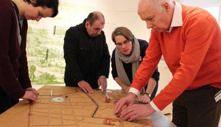 Mehrere Menschen mit Sehbeeinträchtigung ertasten ein Stadtmodell