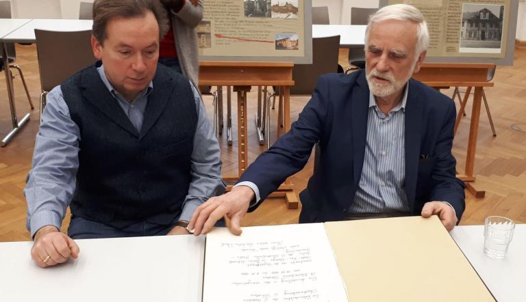 Michael Zajonz und Michael Heinroth präsentieren das Besucherbuch zur Ausstellung,